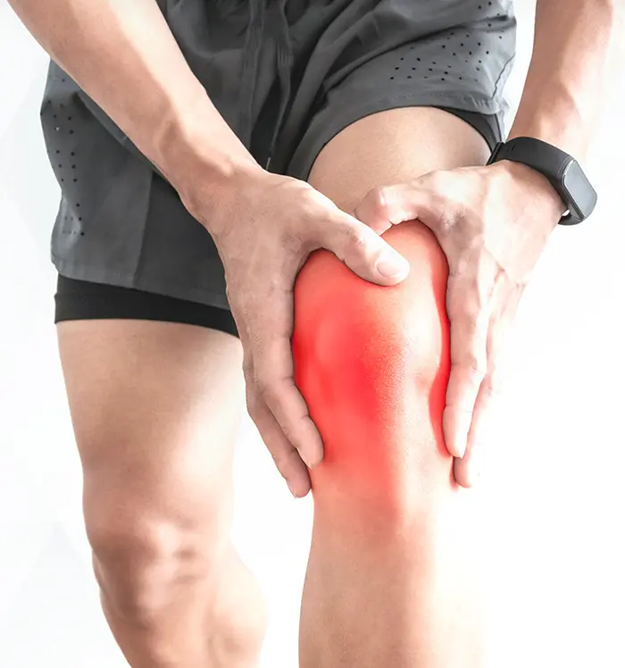 A man clutching his knee, showing signs of knee pain and discomfort