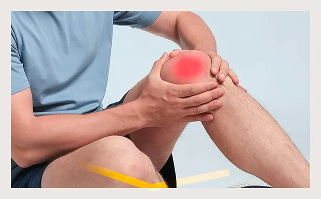 A seated man clutching his knee, showing signs of pain and discomfort
