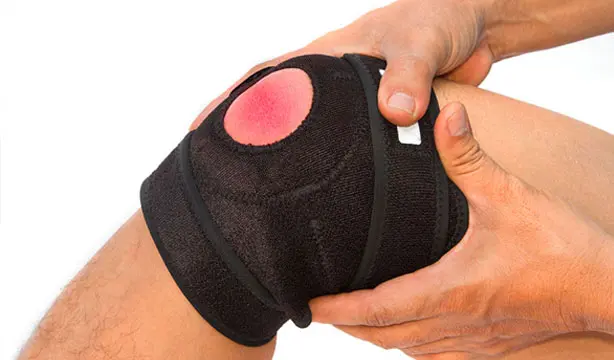 A man holding his knee in pain, showing signs of an ACL injury