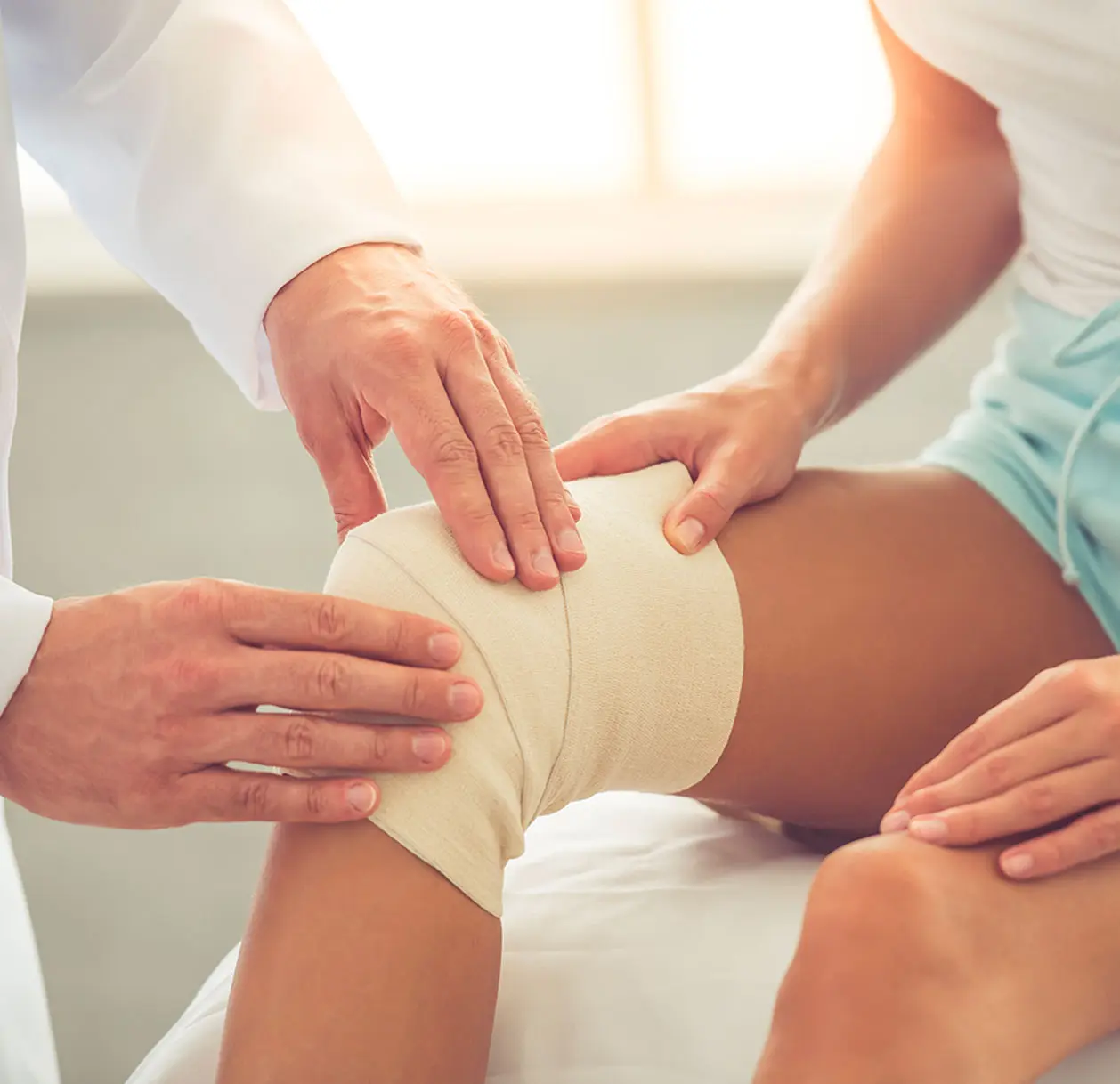 A woman holding her knee in pain, showing signs of a dislocated knee joint