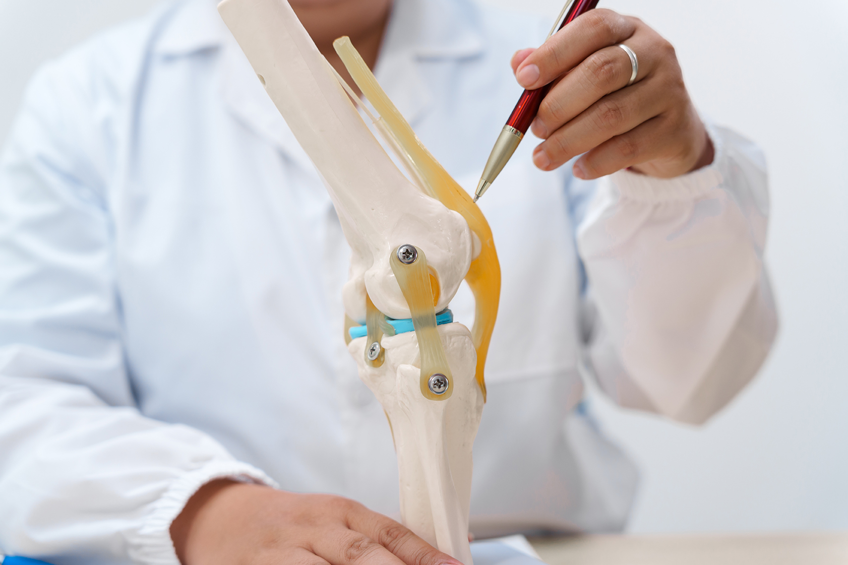 A doctor pointing to a diagram of a knee.