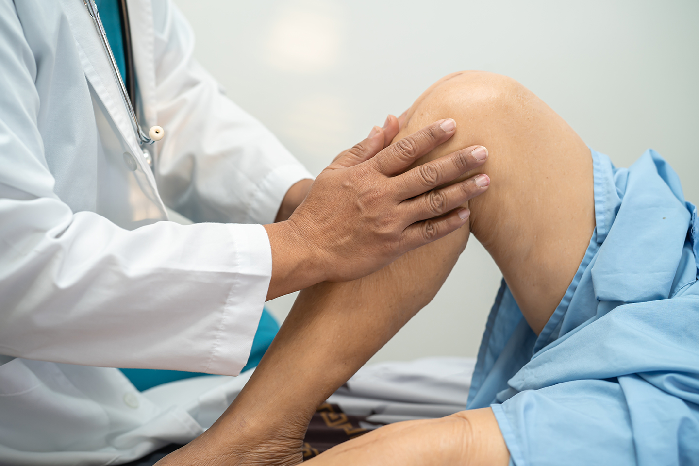 A doctor examining a patient’s knee.